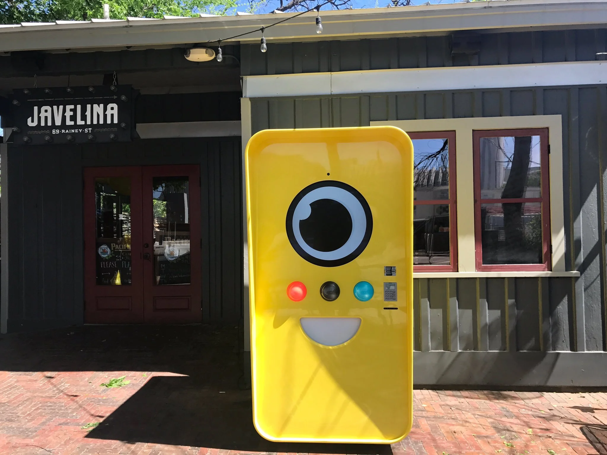 Yellow Snapbot vending machine standing outside the Javelina bar on Rainey Street in Austin